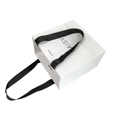 एम्बॉसिंग रिबन हैंडल कॉस्मेटिक पेपर बैग व्हाइट पेपर कैरियर बैग